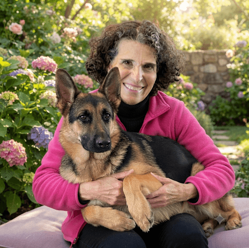 Smiling woman in a pink jacket embraces a German Shepherd dog in a garden.